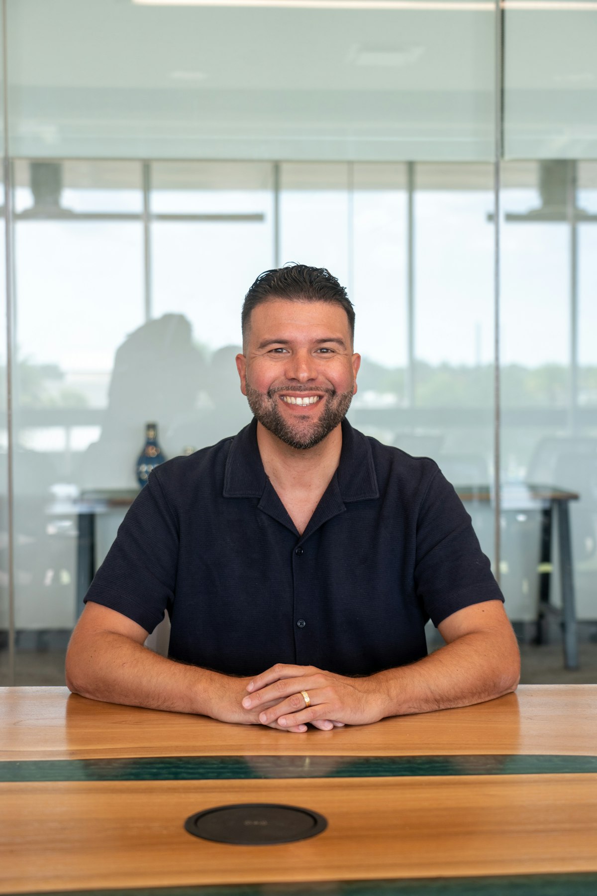 Daniel Reyes, co-founder and CEO of ondine, smiling at a wooden table
