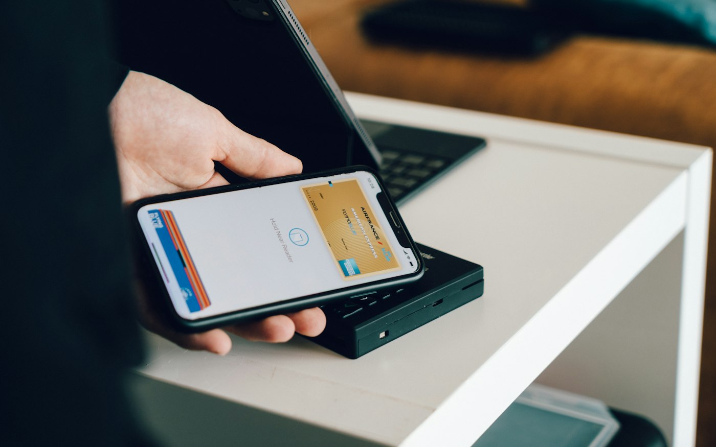 Customer tapping a phone on a card reader at a market stall